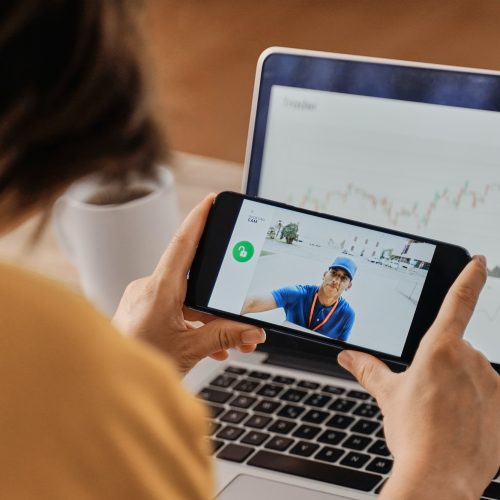 woman-watching-delivery-man-on-security-camera-video-on-mobile-phone-while-working-at-home-office.jpg