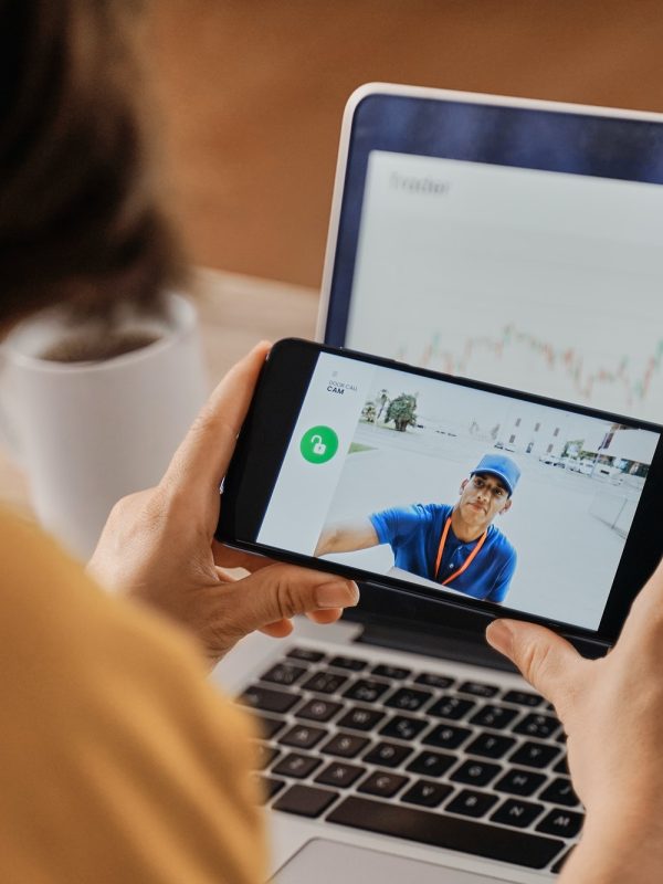 woman-watching-delivery-man-on-security-camera-video-on-mobile-phone-while-working-at-home-office.jpg